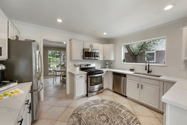 19 Shinyrock Pl, The Woodlands, TX 77381 - kitchen with stainless steel appliances, white cabinets, light tile patterned floors, recessed lighting, and crown molding