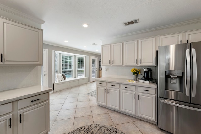 19 Shinyrock Pl, The Woodlands, TX 77381 - kitchen featuring stainless steel refrigerator with ice dispenser, ornamental molding, light countertops, light tile patterned floors, and white cabinets