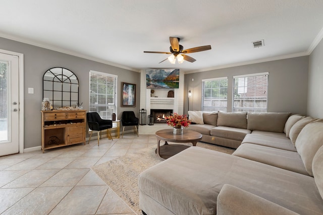 19 Shinyrock Pl, The Woodlands, TX 77381 - living room featuring light tile patterned floors, ornamental molding, a ceiling fan, and a large fireplace