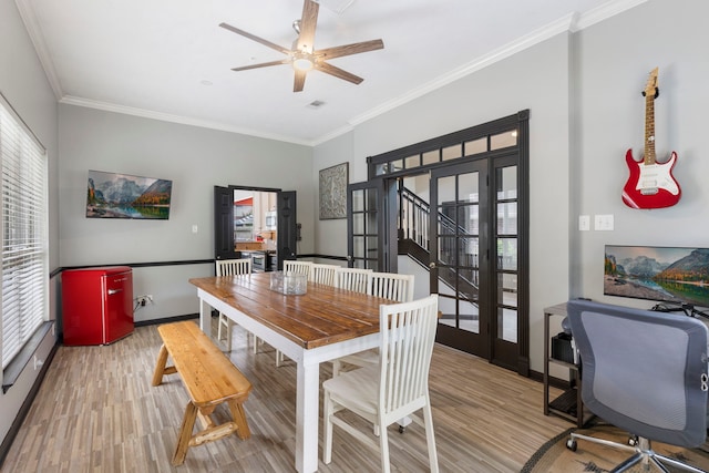 96 N Acacia Park Cir, The Woodlands, TX 77382 - dining area featuring crown molding, light wood finished floors, a ceiling fan, and stairs