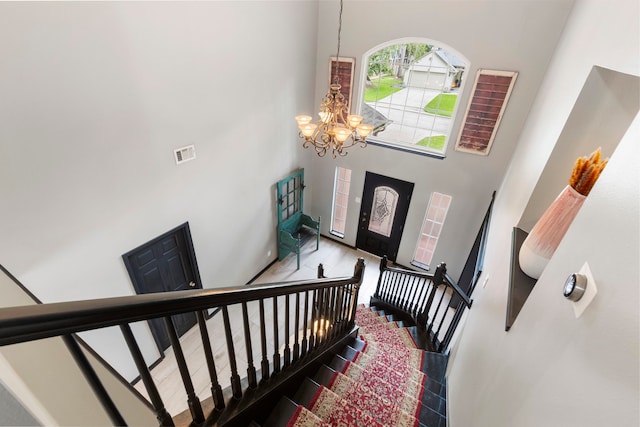 96 N Acacia Park Cir, The Woodlands, TX 77382 - entrance foyer featuring a chandelier, a towering ceiling, wood finished floors, and stairs