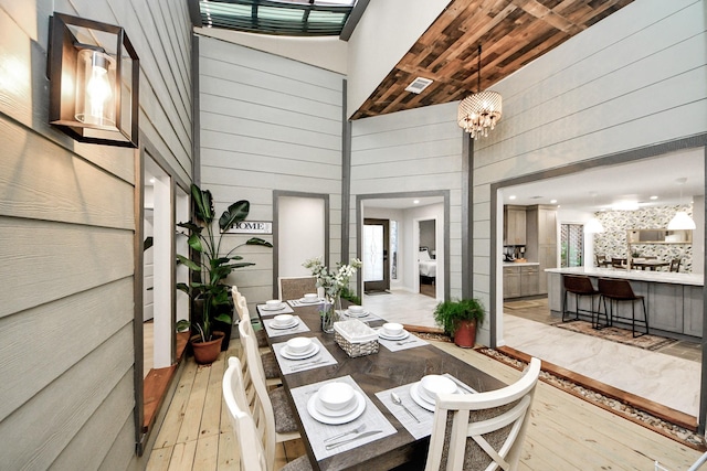 6803 Las Brisas Dr, Houston, TX 77083 - dining room with light wood-style flooring, a high ceiling, and wood walls