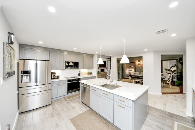 6803 Las Brisas Dr, Houston, TX 77083 - kitchen featuring stainless steel appliances, gray cabinetry, recessed lighting, an island with sink, and light stone countertops