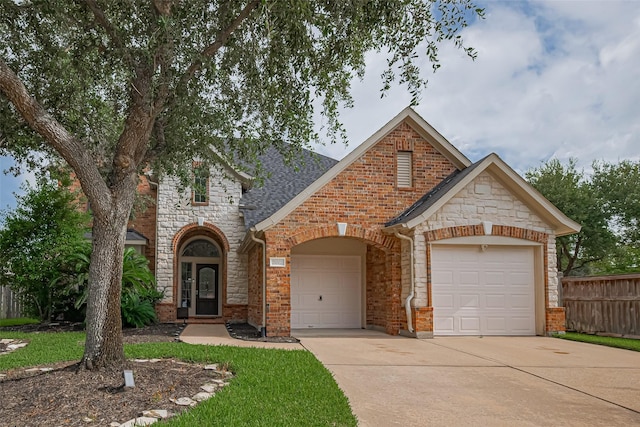 21002 Beech Landing Ln, Katy, TX 77450 - view of front of house featuring concrete driveway, a garage, stone siding, brick siding, and a shingled roof
