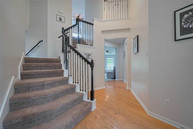 21002 Beech Landing Ln, Katy, TX 77450 - stairs featuring wood finished floors, a ceiling fan, and a towering ceiling