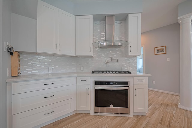 21002 Beech Landing Ln, Katy, TX 77450 - kitchen with appliances with stainless steel finishes, wall chimney range hood, light countertops, and white cabinets