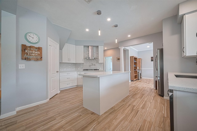 21002 Beech Landing Ln, Katy, TX 77450 - kitchen with wall chimney exhaust hood, freestanding refrigerator, light wood-style flooring, white cabinetry, and tasteful backsplash