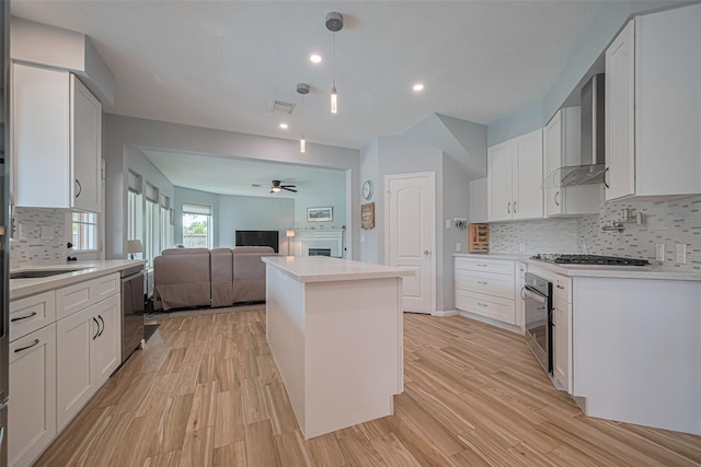 21002 Beech Landing Ln, Katy, TX 77450 - kitchen featuring wall chimney exhaust hood, stainless steel appliances, decorative backsplash, a fireplace, and ceiling fan