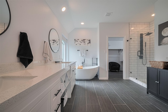 21002 Beech Landing Ln, Katy, TX 77450 - full bathroom with a stall shower, double vanity, a freestanding tub, a walk in closet, and recessed lighting