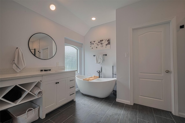 21002 Beech Landing Ln, Katy, TX 77450 - bathroom with a freestanding bath, vaulted ceiling, vanity, and wood finish floors