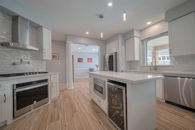 21002 Beech Landing Ln, Katy, TX 77450 - kitchen with stainless steel appliances, wine cooler, wall chimney exhaust hood, light countertops, and white cabinets