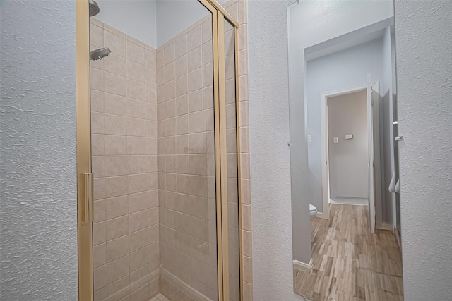 21002 Beech Landing Ln, Katy, TX 77450 - bathroom featuring a shower stall, a textured wall, and wood finished floors