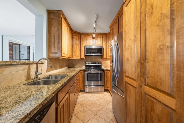 2829 Timmons Ln Unit 101, Houston, TX 77027 - kitchen with appliances with stainless steel finishes, light stone counters, backsplash, brown cabinets, and light tile patterned floors