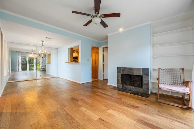 2829 Timmons Ln Unit 101, Houston, TX 77027 - unfurnished living room featuring a chandelier, wood-type flooring, crown molding, ceiling fan, and a tile fireplace