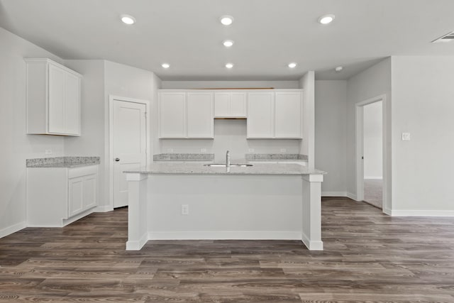 645 Blackberry Ln, La Marque, TX 77568 - kitchen featuring an island with sink, white cabinets, dark wood-style floors, recessed lighting, and light stone countertops