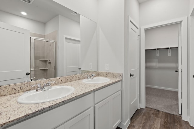 645 Blackberry Ln, La Marque, TX 77568 - full bathroom featuring a shower stall, double vanity, a spacious closet, and wood finished floors