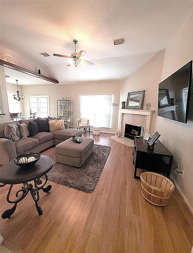 4134 Teal Valley Ct, Fresno, TX 77545 - living area featuring wood finished floors, a tiled fireplace, a ceiling fan, a textured ceiling, and lofted ceiling