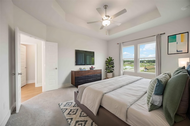 13208 Opera Dr, Houston, TX 77047 - bedroom featuring a tray ceiling, light colored carpet, and ceiling fan