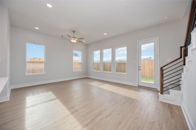 13208 Opera Dr, Houston, TX 77047 - unfurnished living room with stairs, light wood finished floors, ceiling fan, and recessed lighting