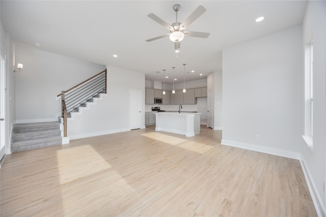 13208 Opera Dr, Houston, TX 77047 - unfurnished living room with stairway, light wood finished floors, ceiling fan, and recessed lighting