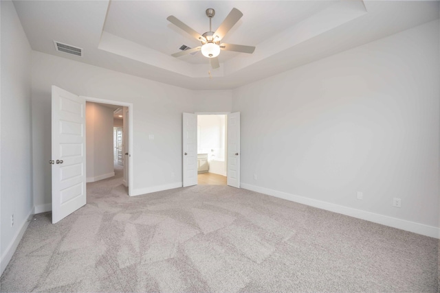 13208 Opera Dr, Houston, TX 77047 - unfurnished bedroom featuring a raised ceiling, light carpet, connected bathroom, and ceiling fan