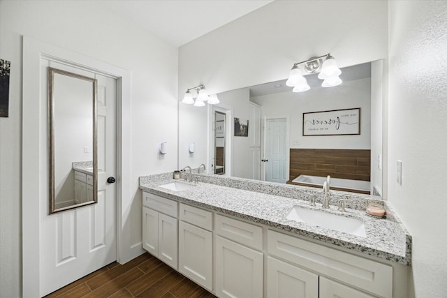 2201 Maple St, Liberty, TX 77575 - bathroom featuring double vanity, wood finished floors, and a bath