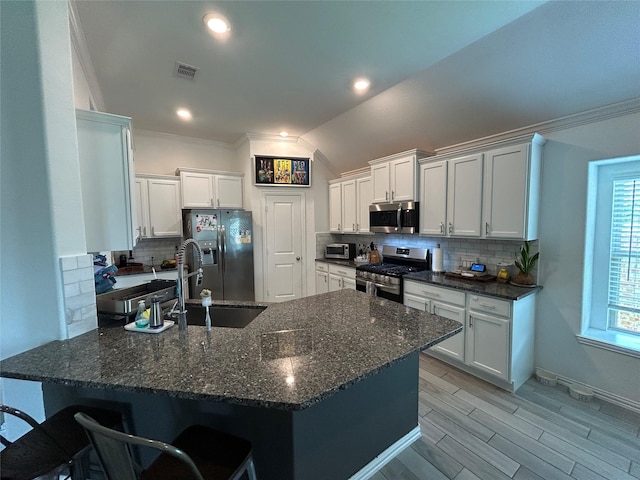 20130 New Sunrise Trl, Cypress, TX 77433 - kitchen featuring stainless steel appliances, a peninsula, tasteful backsplash, crown molding, and dark stone counters