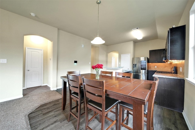 7427 Wheatley Gardens Dr, Houston, TX 77016 - dining room with arched walkways and dark wood-style flooring