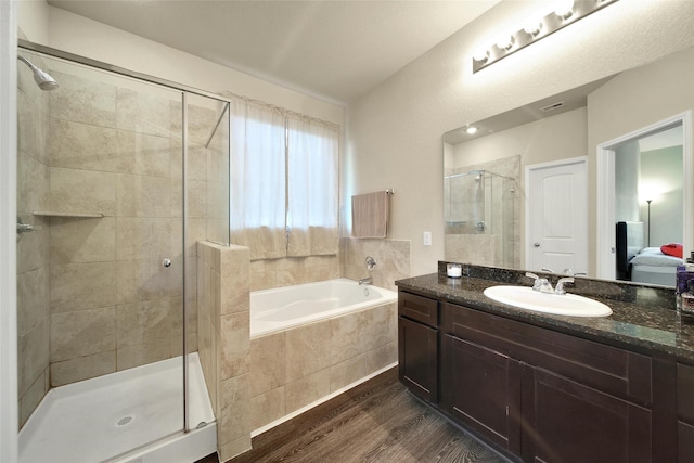 7427 Wheatley Gardens Dr, Houston, TX 77016 - bathroom with a garden tub, wood finished floors, a stall shower, and vanity