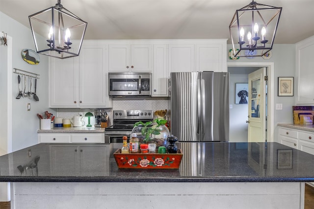 502 Spinn St, Brenham, TX 77833 - kitchen with appliances with stainless steel finishes, a chandelier, a kitchen island, and white cabinetry