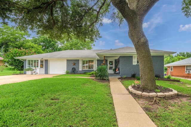 502 Spinn St, Brenham, TX 77833 - ranch-style home featuring an attached garage, a front lawn, brick siding, concrete driveway, and cooling unit