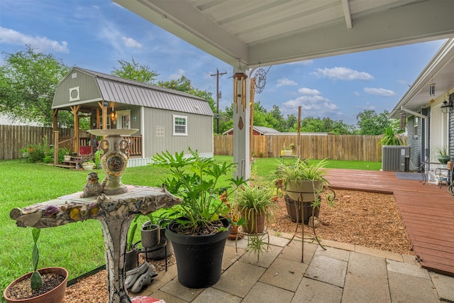 502 Spinn St, Brenham, TX 77833 - fenced backyard with a wooden deck, an outbuilding, and a patio