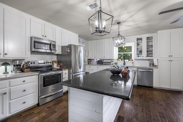 502 Spinn St, Brenham, TX 77833 - kitchen with stainless steel appliances, a chandelier, tasteful backsplash, white cabinetry, and dark wood-style flooring