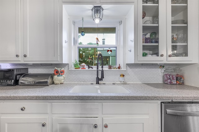 502 Spinn St, Brenham, TX 77833 - kitchen with glass insert cabinets, white cabinetry, backsplash, and stainless steel dishwasher