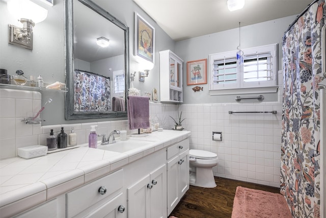 502 Spinn St, Brenham, TX 77833 - bathroom featuring wood finished floors, vanity, wainscoting, and tile walls