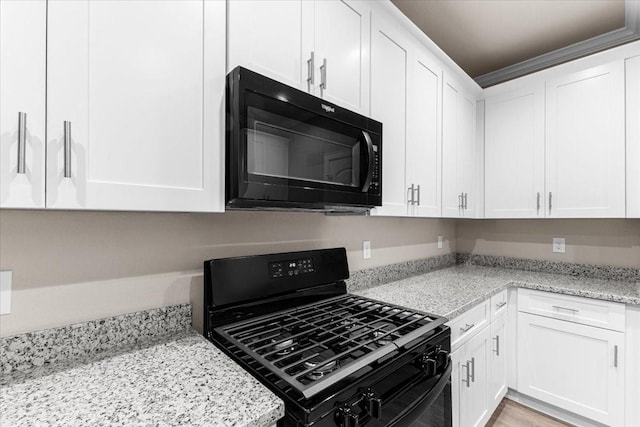7970 Fowlie St, Houston, TX 77028 - kitchen with black appliances, white cabinetry, light stone countertops, and crown molding