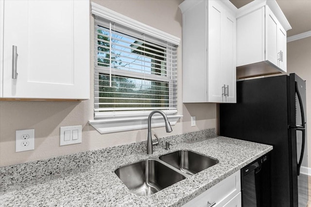 7970 Fowlie St, Houston, TX 77028 - kitchen with white cabinetry, black appliances, light stone countertops, and ornamental molding
