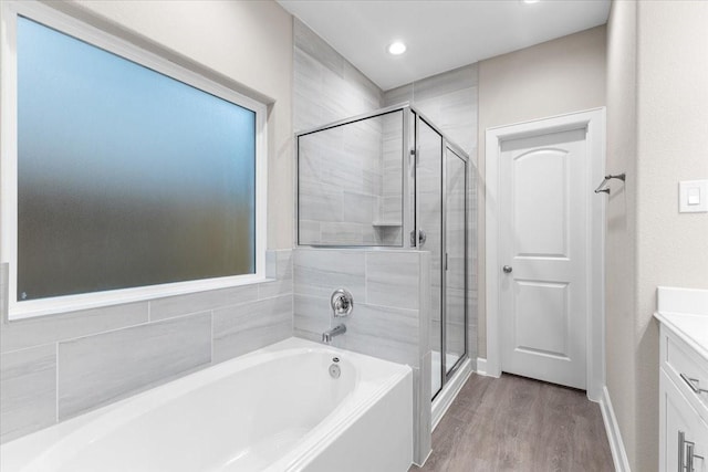 7970 Fowlie St, Houston, TX 77028 - full bathroom featuring a bath, a shower stall, vanity, wood finished floors, and recessed lighting