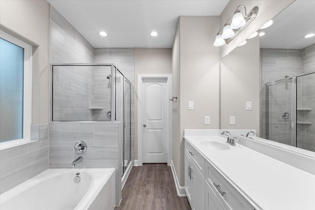 7970 Fowlie St, Houston, TX 77028 - bathroom with vanity, a stall shower, a garden tub, wood finished floors, and recessed lighting