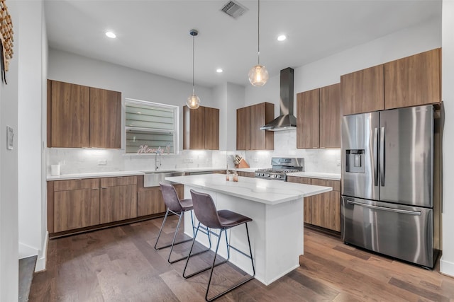 413 N Nagle St Unit B, Houston, TX 77003 - kitchen featuring appliances with stainless steel finishes, wall chimney range hood, brown cabinets, modern cabinets, and recessed lighting