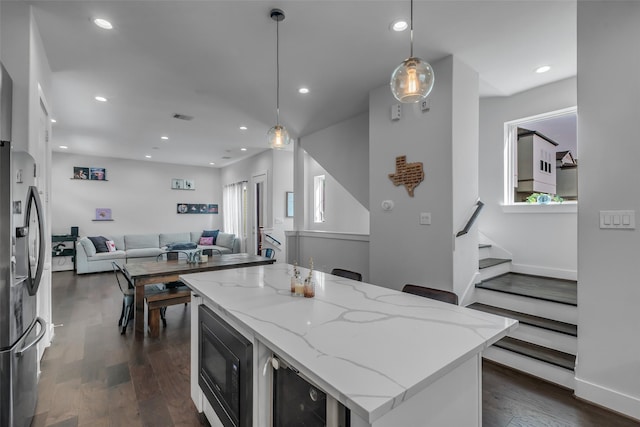 413 N Nagle St Unit B, Houston, TX 77003 - kitchen with black microwave, stainless steel fridge, open floor plan, dark wood-type flooring, and pendant lighting