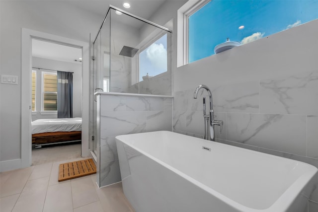 413 N Nagle St Unit B, Houston, TX 77003 - ensuite bathroom featuring a freestanding tub, a shower stall, tile patterned floors, and tile walls