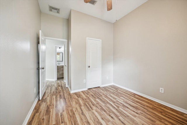 2708 Courtyard Ln, Pearland, TX 77584 - unfurnished bedroom with light wood-type flooring, a towering ceiling, and a ceiling fan