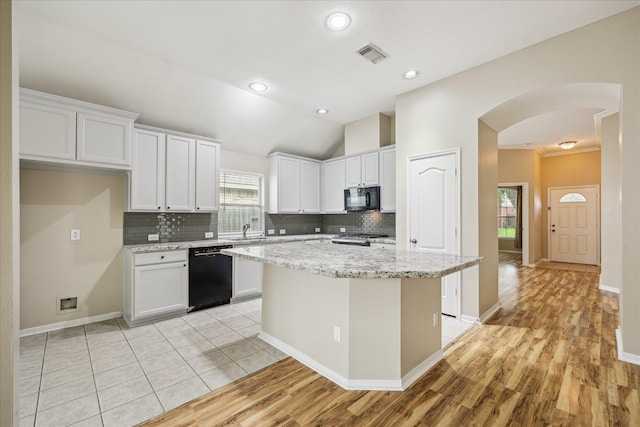 2708 Courtyard Ln, Pearland, TX 77584 - kitchen with black appliances, decorative backsplash, white cabinets, light wood finished floors, and lofted ceiling