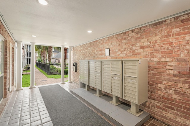 355 N Post Oak Ln Unit 839, Houston, TX 77024 - view of property's community featuring brick wall, floor to ceiling windows, recessed lighting, decorative columns, and mail area