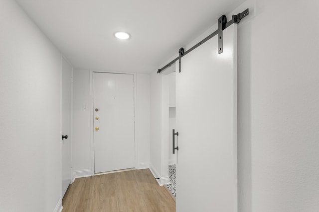 355 N Post Oak Ln Unit 839, Houston, TX 77024 - hall with a barn door and light wood-style flooring