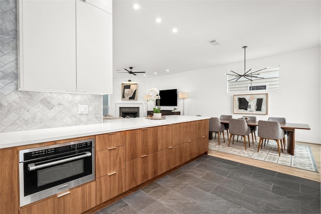 1801 Oneil St Unit C, Houston, TX 77019 - kitchen featuring a fireplace, modern cabinets, stainless steel oven, decorative backsplash, and recessed lighting