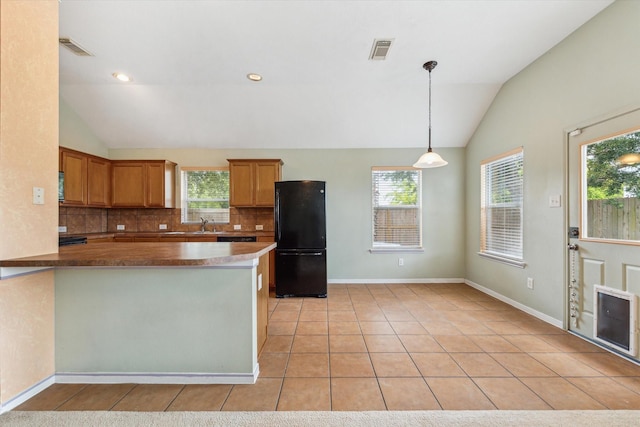 10207 Olive Mount St, Pearland, TX 77584 - kitchen featuring freestanding refrigerator, lofted ceiling, tasteful backsplash, light tile patterned floors, and decorative light fixtures