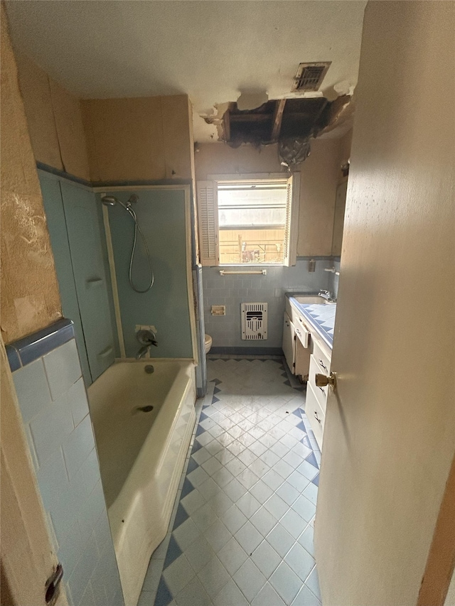 1904 Lillian St, Pasadena, TX 77502 - full bathroom featuring vanity, heating unit, tile patterned flooring, and washtub / shower combination