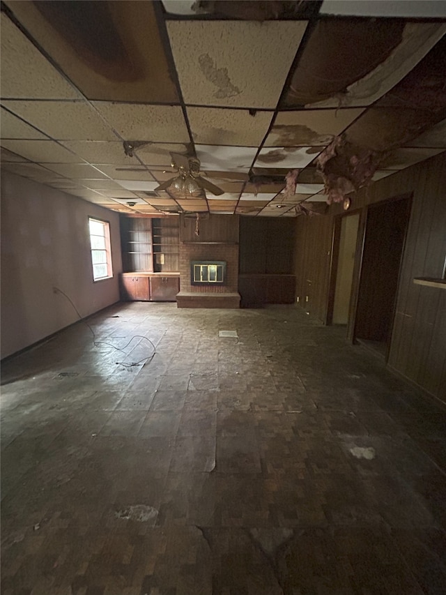 1904 Lillian St, Pasadena, TX 77502 - basement with a fireplace, ceiling fan, a paneled ceiling, and wood walls